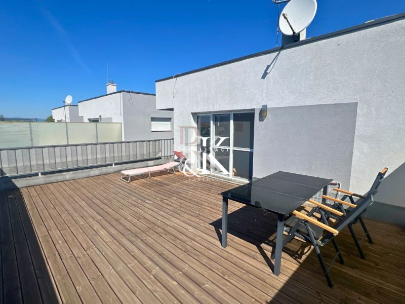 The terrace of a family house in Boldog with a lounger, table, and flooring with a wooden decor.