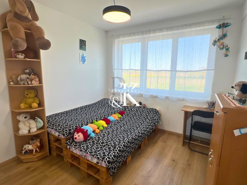 Children's room in a family house with a wooden decor floor and lots of plush toys.