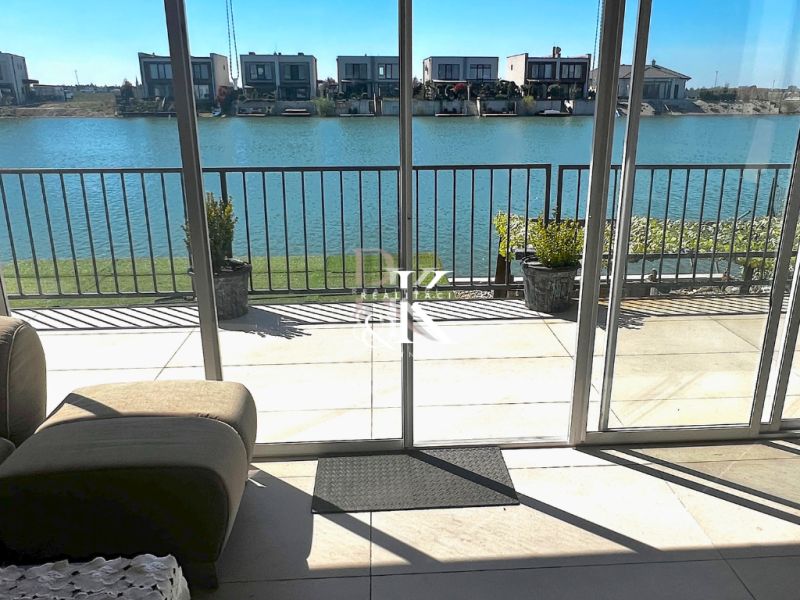 The interior of a family house with a view of the lake through glass doors.