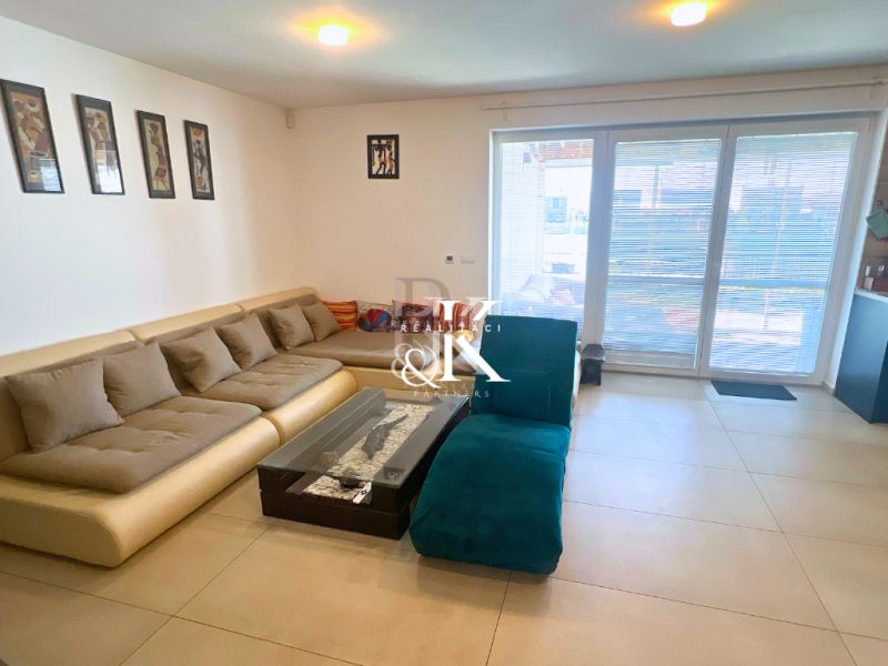 Living room in a family house with a comfortable couch and large glass doors.