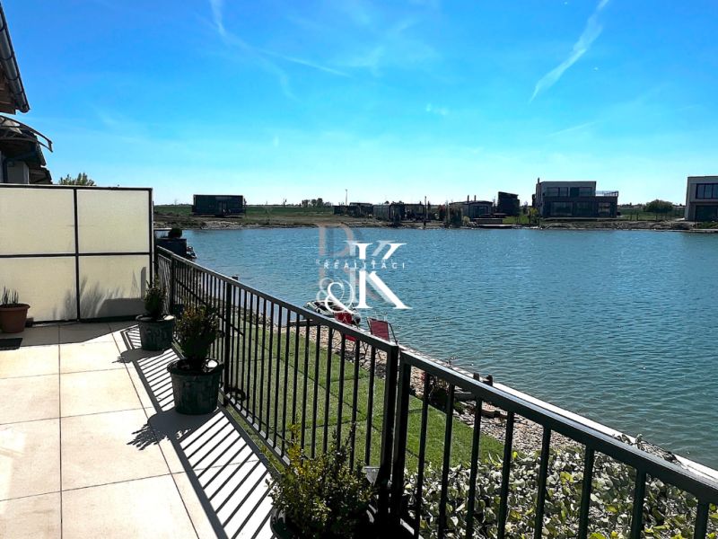 View from the terrace of a family house in Boldog to the lake and nearby plots.