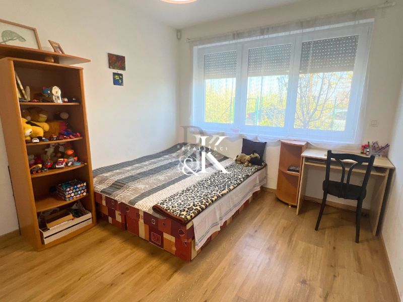 Children's room in a family house with a wooden decor floor, bed, and toys.