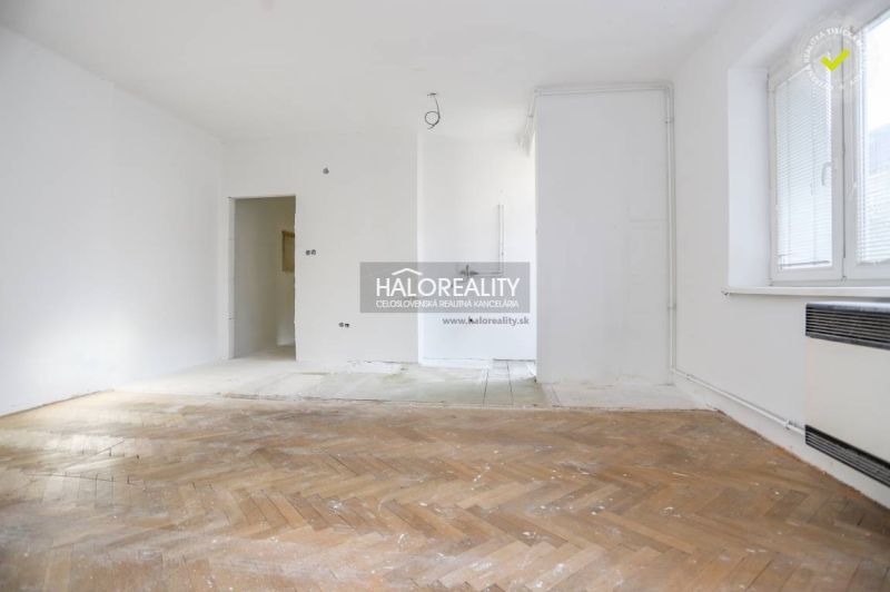 A spacious room in a 3-room apartment with a wooden decor floor and white walls.