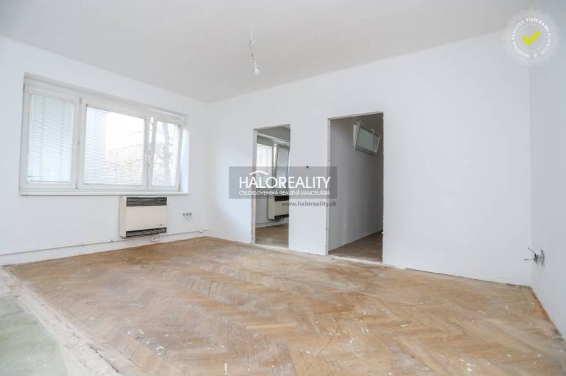 The 3-room apartment is dominated by a light wall and a floor with a wooden decor.