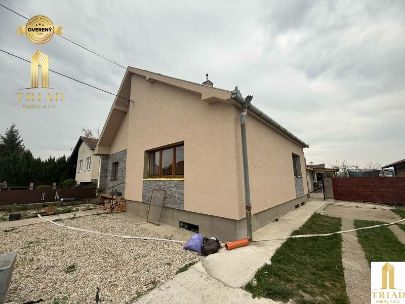 A family house in Huli with an ochre facade and gray stone cladding.