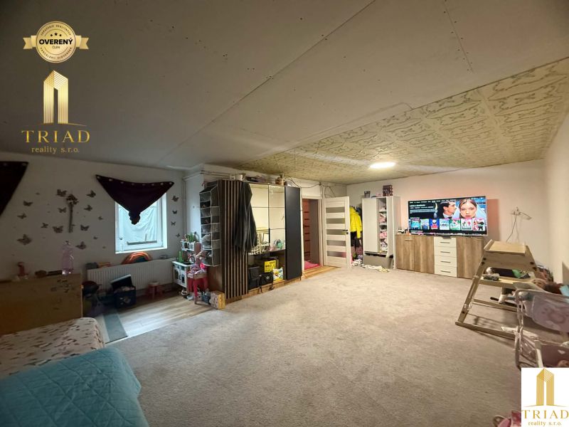 Living room in a family house with comfortable furnishings and a TV on a dresser.