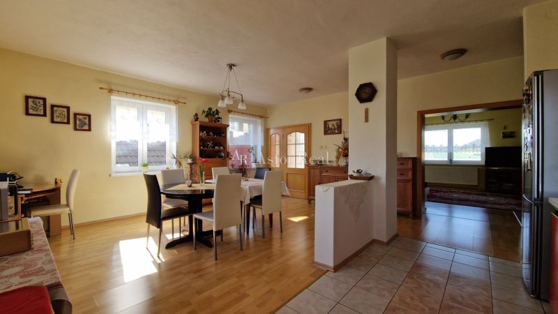 A bright dining room in a family house with a wooden decor floor and furniture.