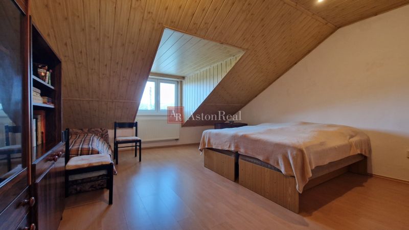 Attic room in a family house with wooden paneling and a wooden decor floor.