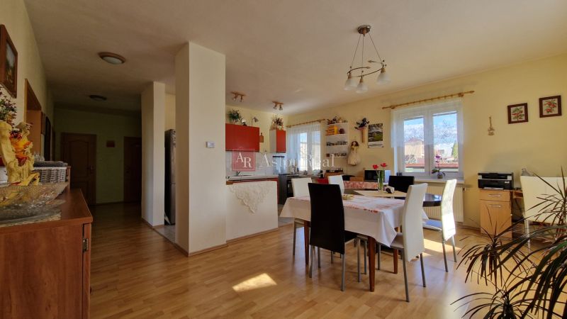 Dining area in a family house with a wooden patterned floor and decorative elements.