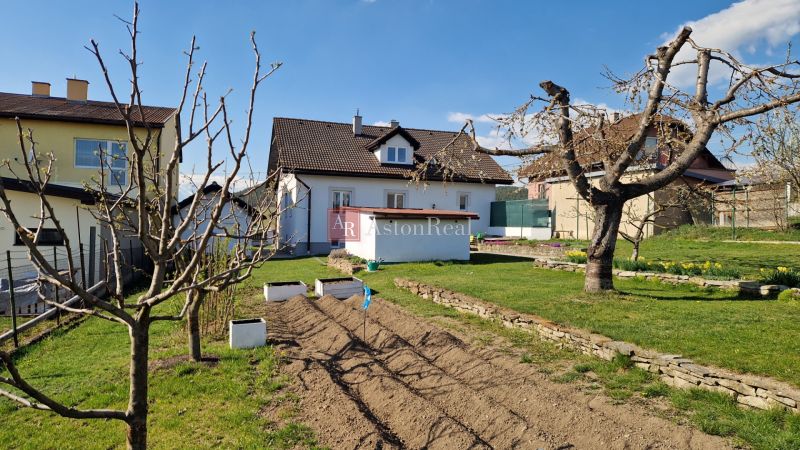 A family house in Spišský Štvrtok with a landscaped garden and young trees.