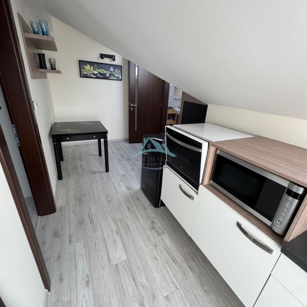 Interior of a family house with a kitchen, microwave, table, and floor with a wood decor.