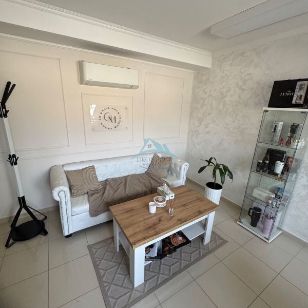 Living room with a white sofa, coffee table, and display cabinet in a family house.