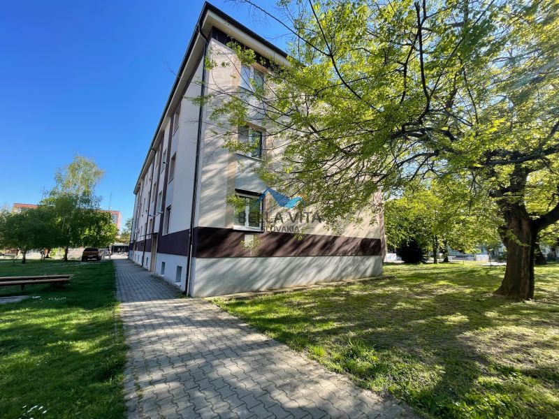 The exterior of the apartment building on Zornička Street in Galanta, surrounding greenery and sidewalk.