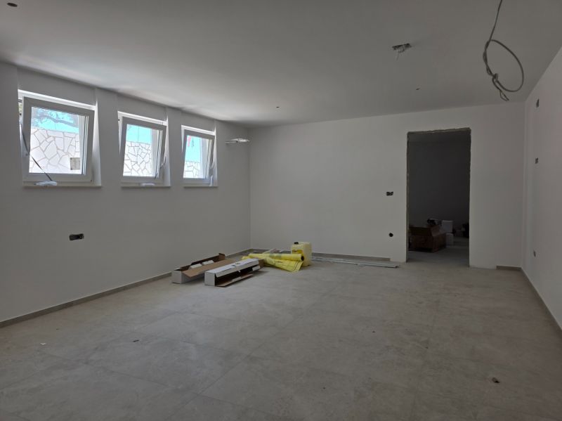 A spacious room in a 3-room apartment with white walls and light tiles.