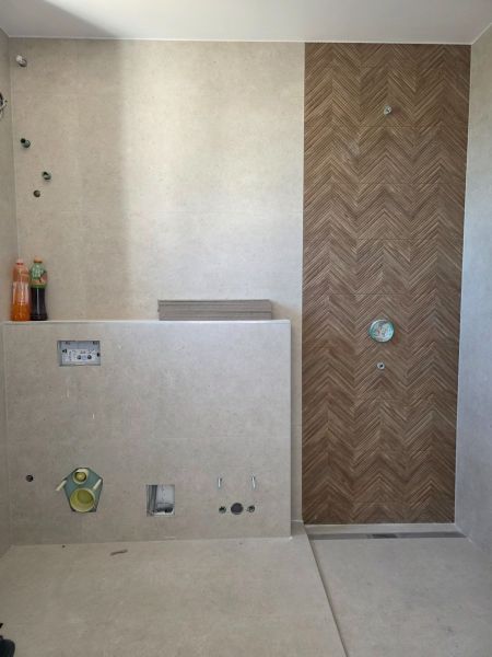 Bathroom in a 3-room apartment with wood decor tiles and prepared installation.