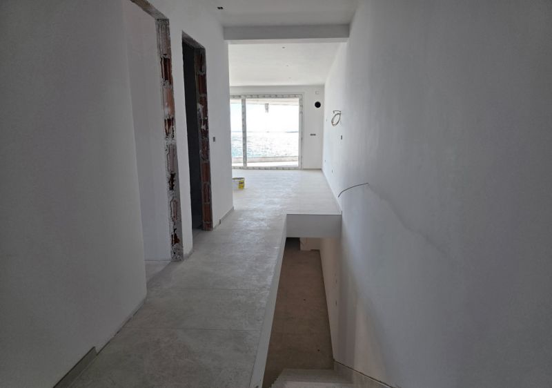 Hallway in a 3-room apartment with a staircase and a view of the balcony door.