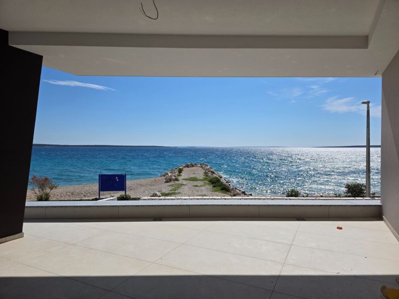 From the terrace of the 3-room apartment in Mandre, there is a view of the sea and the stone pier.