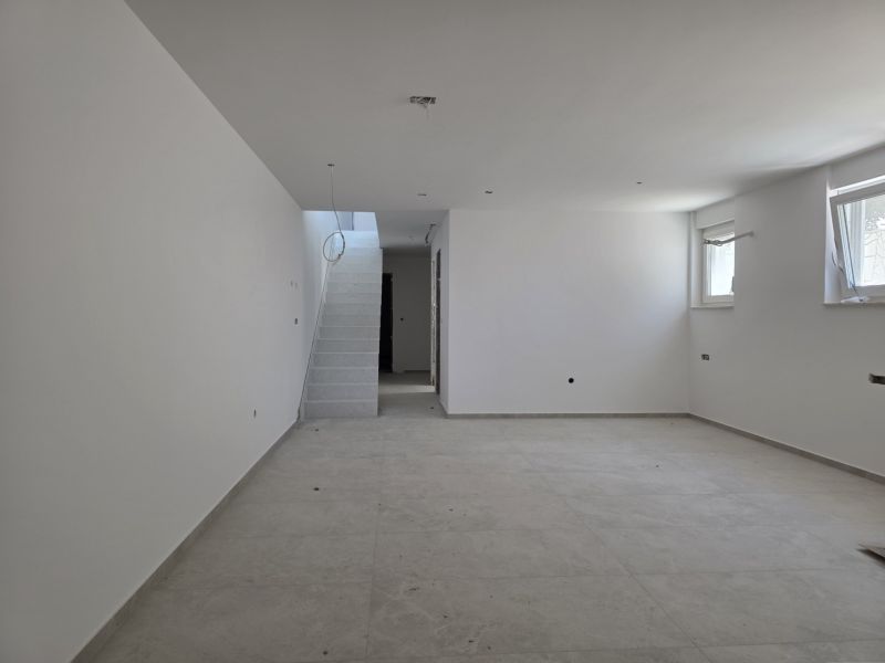 A spacious room in a 3-room apartment with simple stairs and two windows.