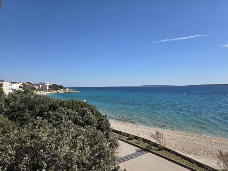 View of the coast with a beach in Mandre, beautiful blue ocean and clear sky.