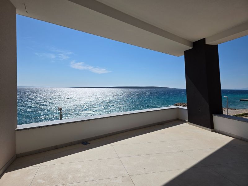 A terrace with a sea view in a 3-room apartment in Mandre, sunny weather, clear sky.