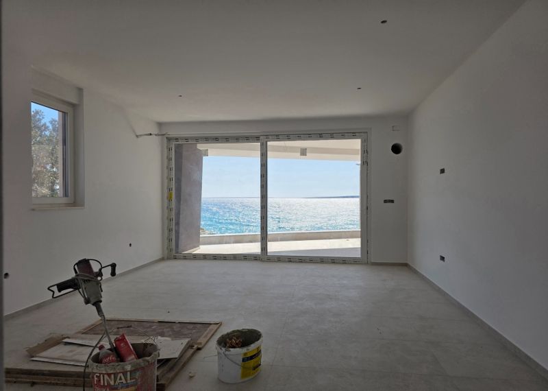The interior of a 3-room apartment with large windows and a view of the sea.