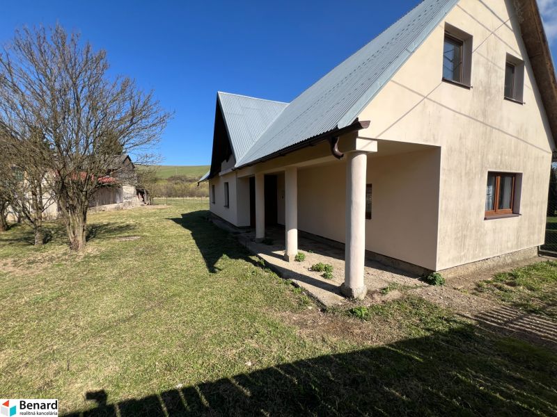 A family house in Vislanka, with a large garden and lawn, under a blue sky.