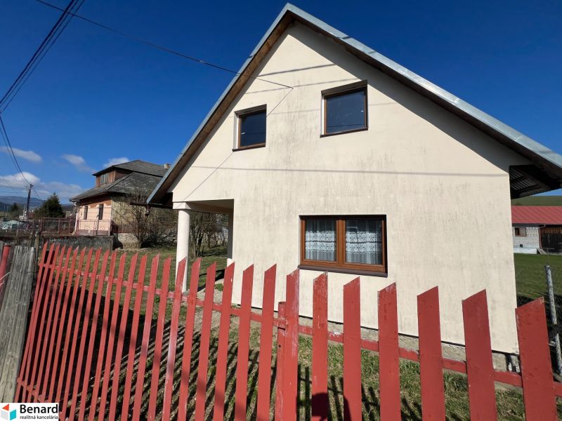 A family house in Vislanka with white plaster and a red fence.