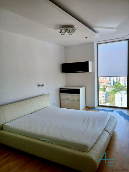 Bedroom in a 2-room apartment with a bed and a nightstand, floor with wood decor.