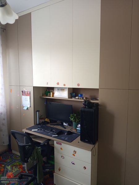 A work corner with an office chair, computer, and storage cabinets in a 3-room apartment.