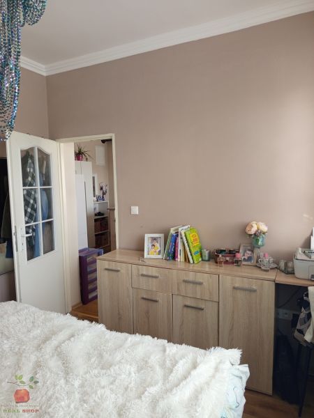 A bright bedroom with a chest of drawers with a wood decor in a 3-room apartment.