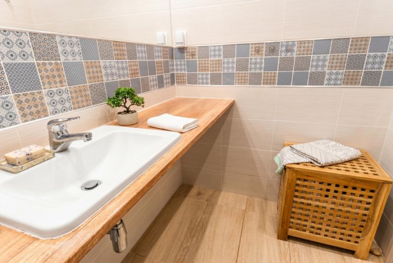 A bathroom with colorful tiles and a wooden decor floor in a 3-room apartment.