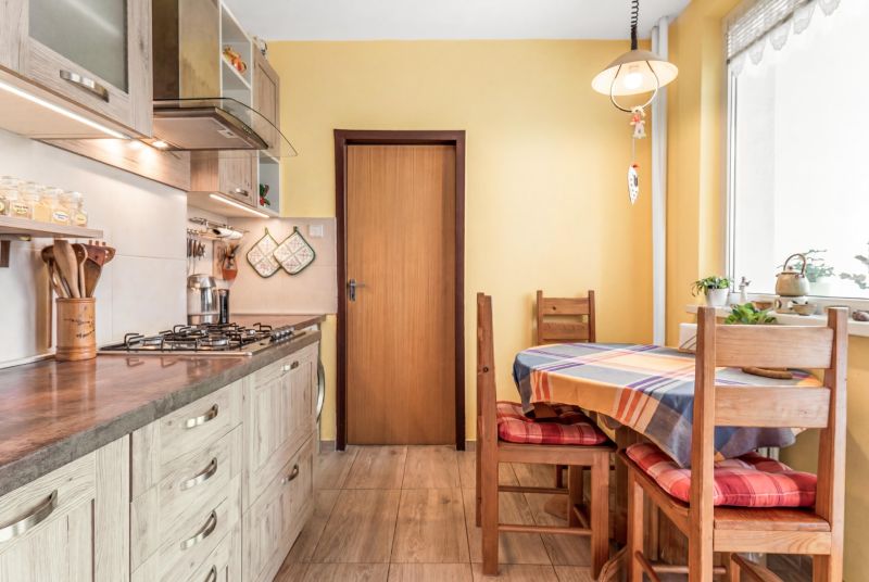 A kitchen in a 3-room apartment with wooden decor and colorful placemats.