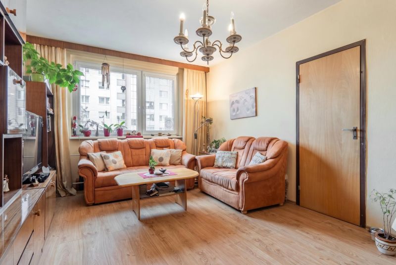 Living room in a 3-room apartment with sofas and a wooden decor floor.