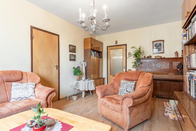 Living room in a 3-room apartment with comfortable armchairs and a wooden decor floor.