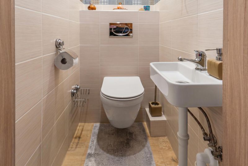 A bathroom in a 3-room apartment with a wooden decor floor and a wall-mounted toilet.