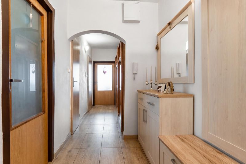 A hallway in a 3-room apartment with wood decor on the furniture and floor.