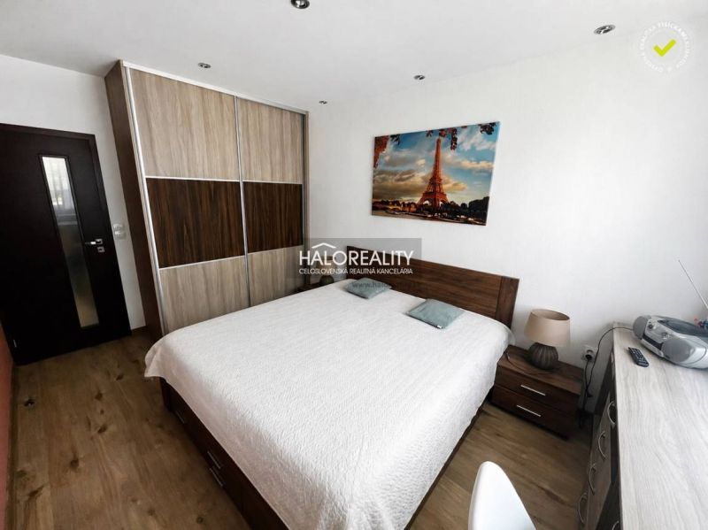 A bedroom in a 3-room apartment with a wardrobe, bed, and wooden decor flooring.