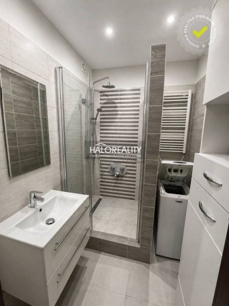 A bathroom in a 3-room apartment with a shower, a washing machine, and a mirrored cabinet.