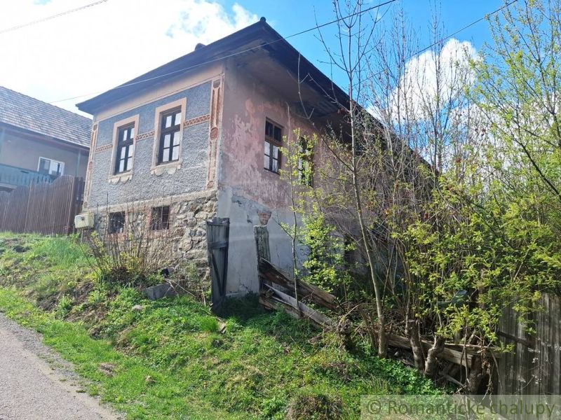 An old stone house in Heľpa, unique property, with a neglected facade and natural surroundings.