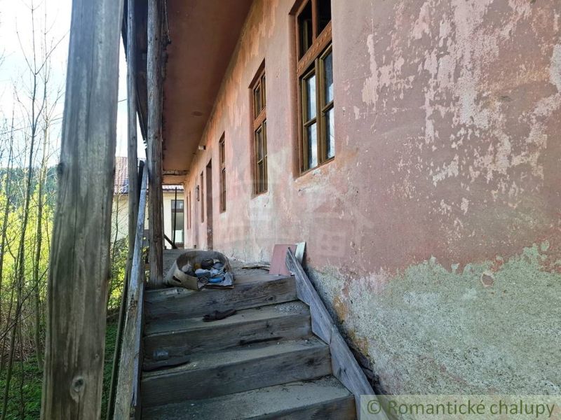 A worn staircase of an older peculiar property in Heľpa, with cracked plaster.
