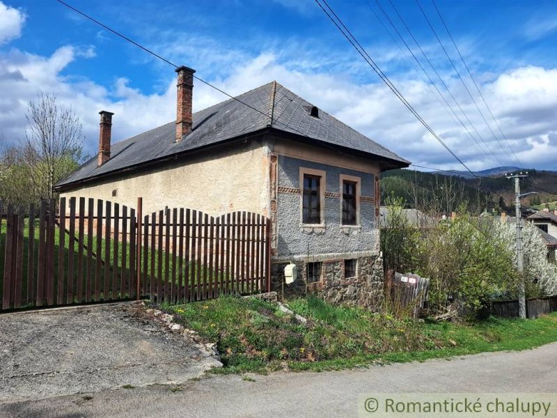 An old building with a sloped roof and a fence in Heľpa, Unusual properties.