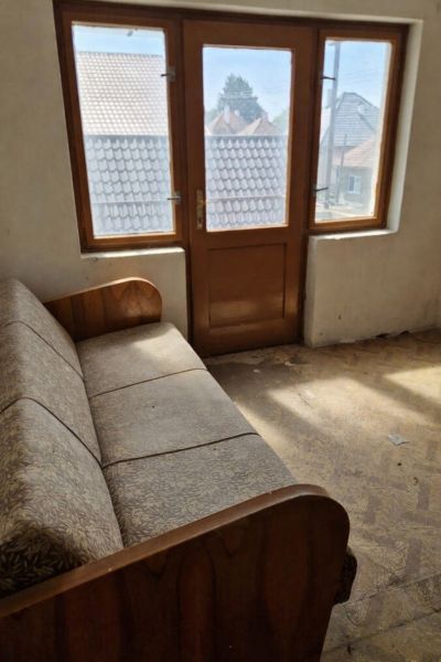 A room in a family house with a sofa and large windows with a view.