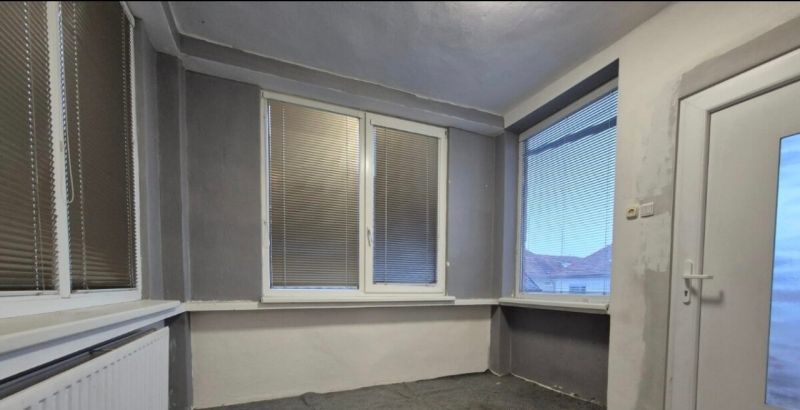 Interior of a family house with plastic windows and blinds, gray walls.