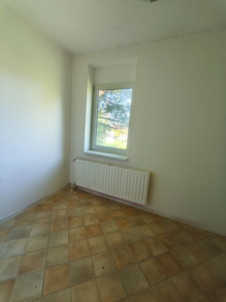 A room in a family house with light ceramic tiles and white walls.