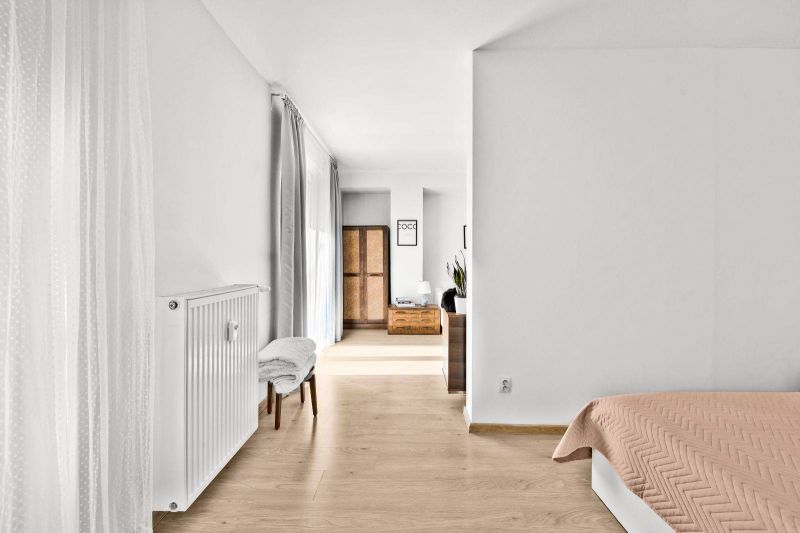 Interior of a 2-room apartment with simple decoration, wooden decor flooring, curtains.