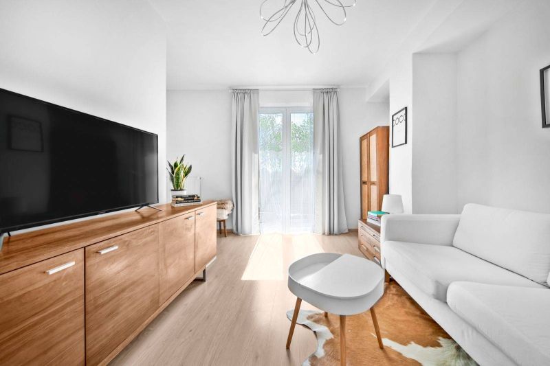 Living room with wood-patterned flooring and furniture in a two-room apartment.