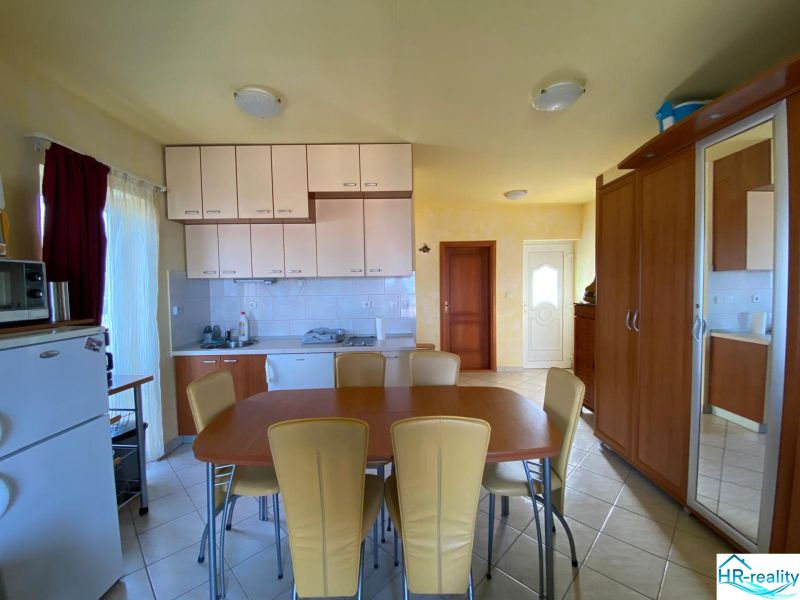 Recreational apartment kitchen with furniture and equipment, including a refrigerator and dining table.