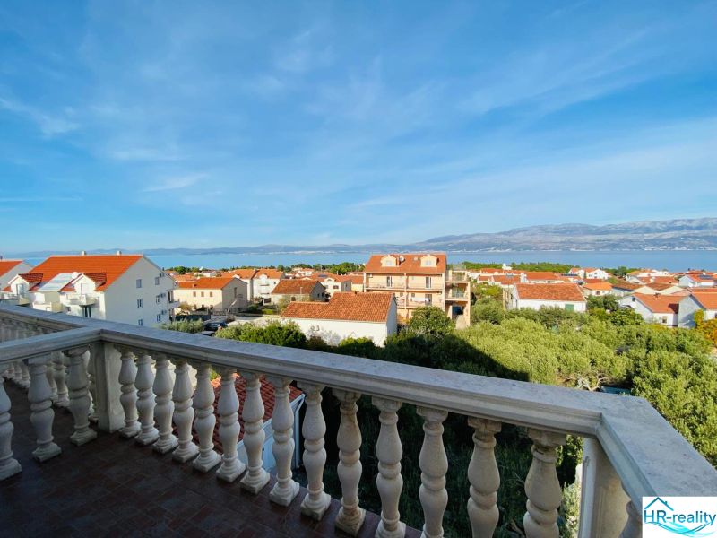 View from the terrace of a holiday apartment in Brač to the sea and rooftops of houses.