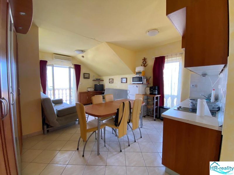 Kitchen in a holiday apartment with a dining table and light-colored walls.