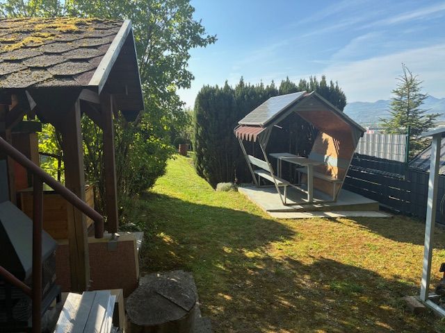 In the garden of the cottage near Ilava, there is a gazebo and a swing surrounded by greenery.